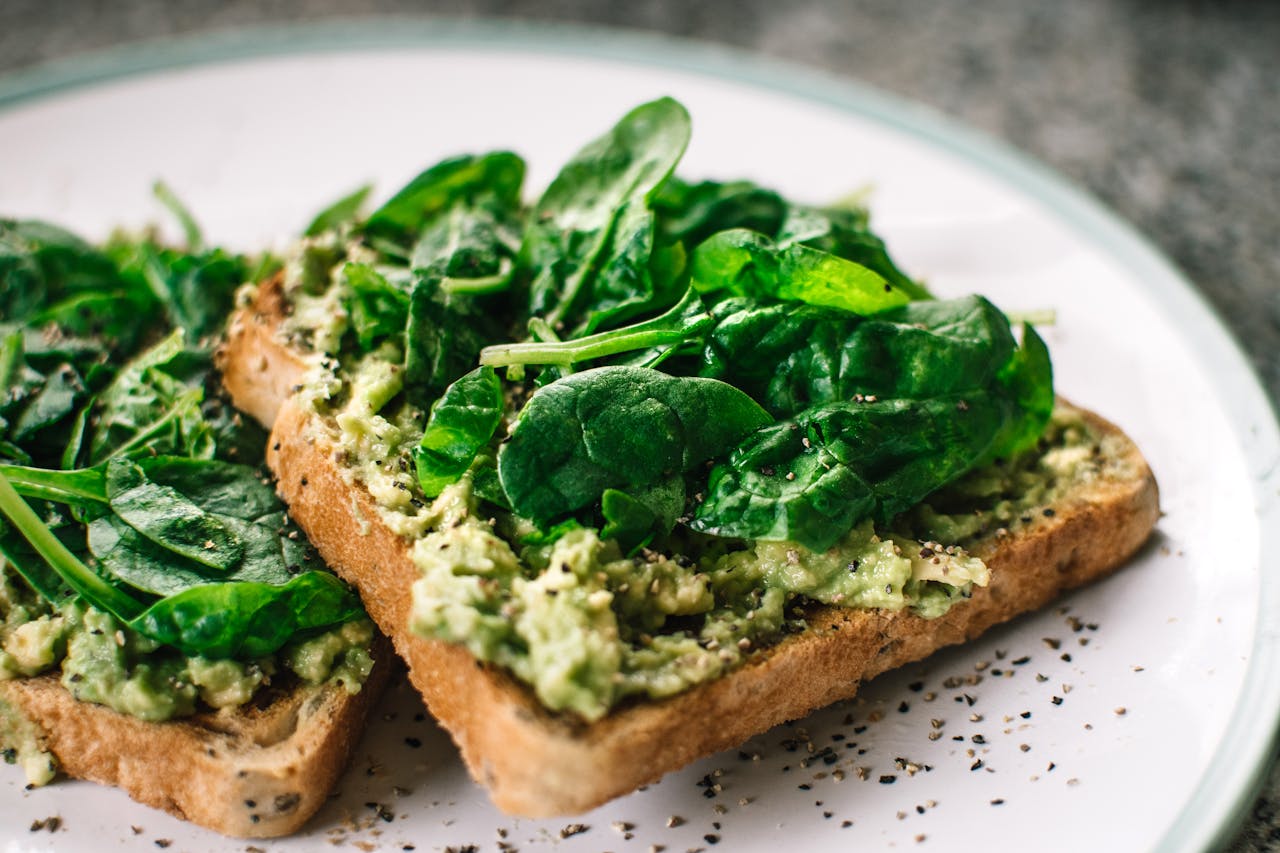 about-01 Close-up of a homemade avocado and spinach sandwich on whole grain toast.