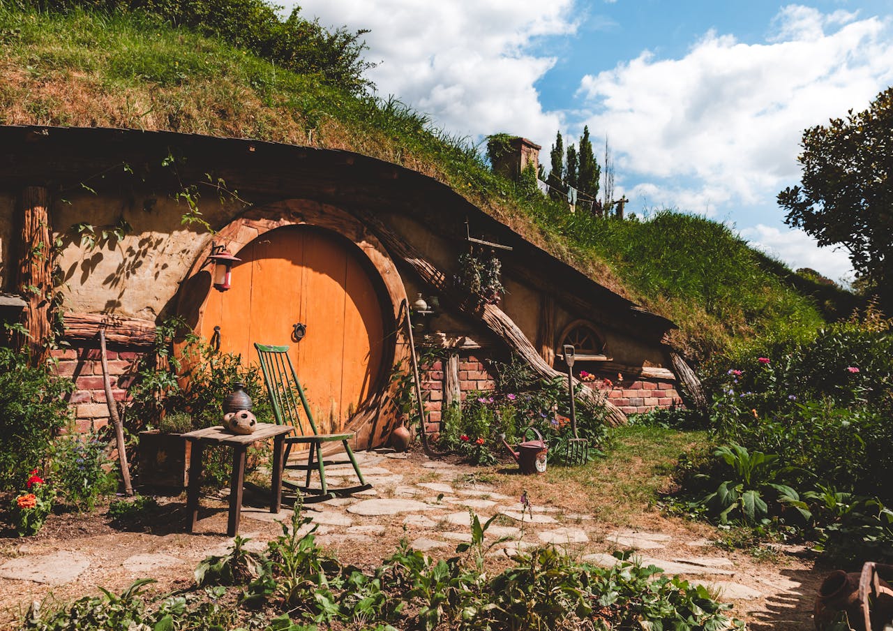 gallery-4 Explore a cozy hobbit house nestled in New Zealand's lush countryside, perfect for a rustic getaway.